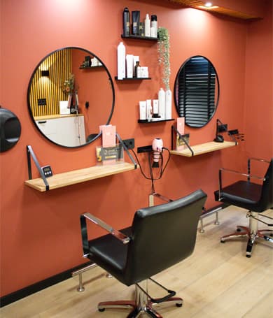 Interieur van de salon met kappersstoelen, ronde spiegels en houten accenten